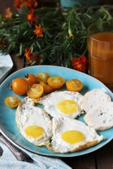 sunny breakfast life style, fried eggs and yellow cherry tomatoes. on a blue plate. yellow and blue