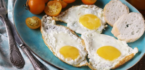sunny breakfast life style, fried eggs and yellow cherry tomatoes. on a blue plate. yellow and blue