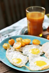 sunny breakfast life style, fried eggs and yellow cherry tomatoes. on a blue plate. yellow and blue