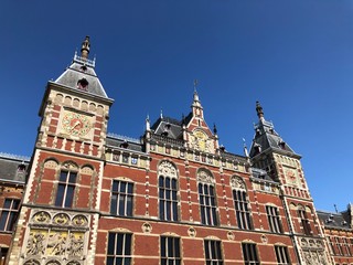 Fototapeta na wymiar Front view of the Amsterdam Central (Centraal) Railway Station in a sunny day, Netherlands