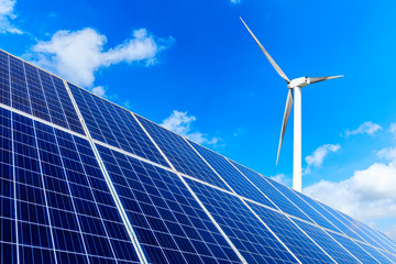 Solar panels with wind turbines on a sunny day,green clean energy concept.