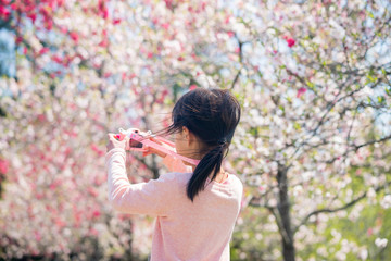 満開の桃の花を見ている子供