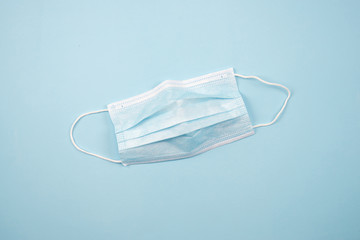 Top view of a medical mask to stop the spread of the virus. On a blue background