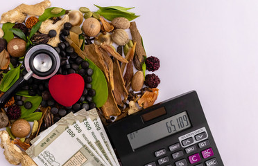 Herbal pills, calculator, stethoscope, money, red heart, composition of spices with green leaves on white background. Medical expenses concept