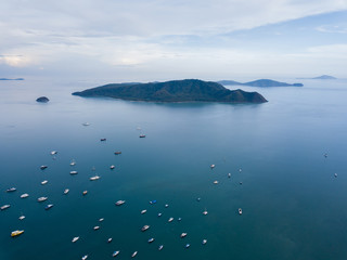 aerial view small picturesque island near parked yachts, cloudy weather at sunset, Chalong bay Phuket Thailand