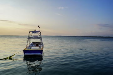 Obraz premium Beautiful landscape view of a boat in calm waters of the ocean near to a pier