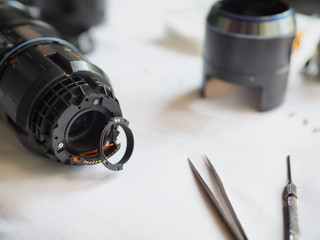 Technician disassembling lens, Disassembly and repair of lens camera by Technician Engineer, Specialist of the center for repair of lens, Selective focus.