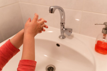 close-up sur les mains d'une petite fille se lavant les mains à un évier