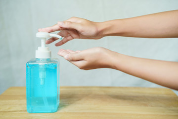 Washing man hands with hand sanitizer alcohol gel on the wooden table medium shot