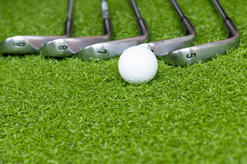 Different golf club and golf ball on green grass background.Outdoor sport.