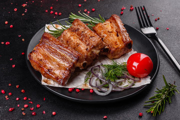 Fried ribs with rosemary, onion, sauce on a concrete background