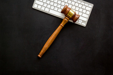 Judge gavel near keyboard - justice and law concept - on black background top-down copy space
