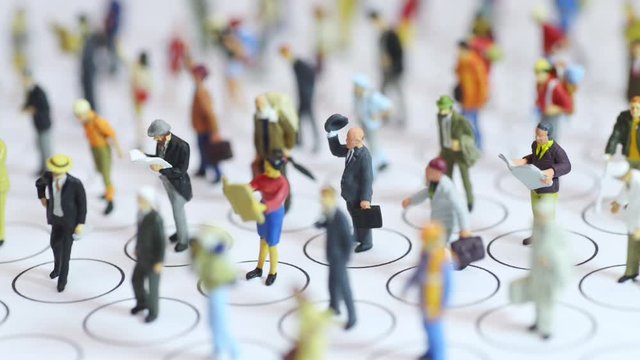 Diagonal focus shifting miniature toys - social distancing conceptual, people distancing each other in public places to avoid infection.