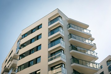 Exterior of new apartment buildings on a blue cloudy sky background. No people. Real estate business concept.