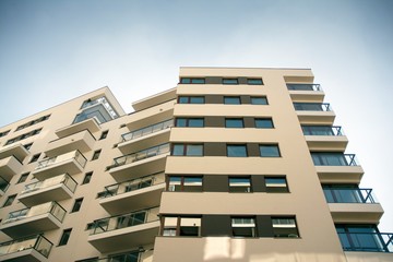 Exterior of new apartment buildings on a blue cloudy sky background. No people. Real estate business concept.