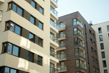 Exterior of new apartment buildings on a blue cloudy sky background. No people. Real estate business concept.