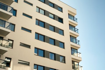 Exterior of new apartment buildings on a blue cloudy sky background. No people. Real estate business concept.