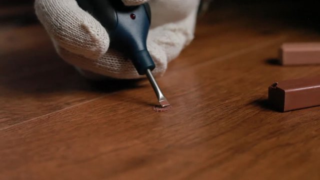 restoration of a parquet of a laminate of a wooden floor with wax and a soldering iron