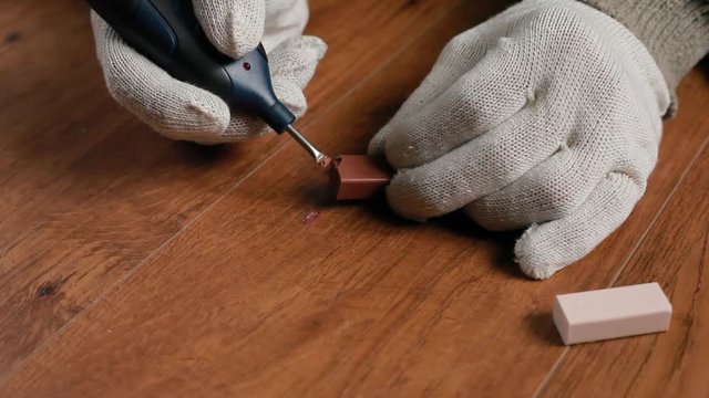 restoration of a parquet of a laminate of a wooden floor with wax and a soldering iron.