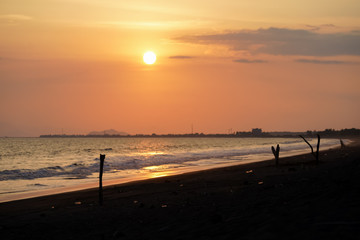 Beautiful sunset on the beach with the silhouette of the palm trees 