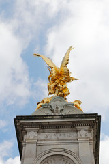 Gilded Winged Victory at the top of the Victoria Memorial in front of Buckingham Palace in a sunny...