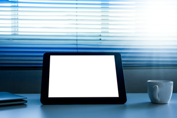 Blank screen tablet computer and a cup of coffee on the table