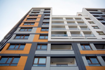 Exterior of new apartment buildings on a blue cloudy sky background. No people. Real estate business concept.