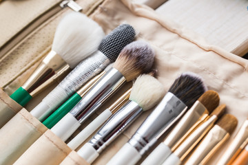 Makeup, beauty and cosmetics concept - Set of make-up brushes in a light case.