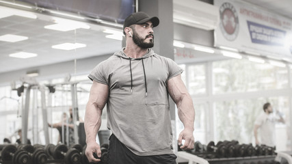 epic strong super hero caucasian man with huge muscle in sport gym during training workout