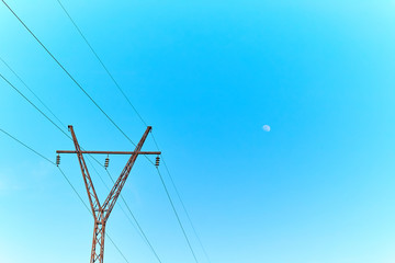 Power lines and electric towers on a background of blue sky.