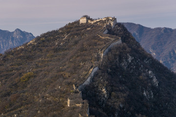 Fototapeta na wymiar A ruined part of Great Wall of China built on the mountain peaks of Jiankou , China