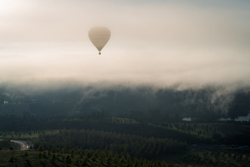Hot air balloon flying in the mist above Canberra, Australia