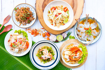 Papaya salad thai and northeast food ,Thai food served on dining table ,Tradition northeast food Isaan delicious on plate with fresh vegetables - Many variety various Thai menu Asian food on a wooden 