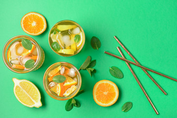 Glasses of tasty cold ice tea on color background