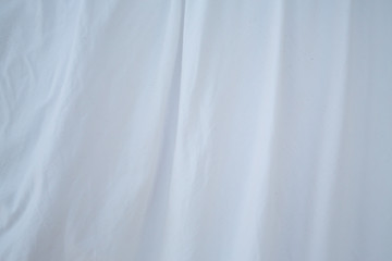 Blurred white bedsheet drying in the sun, Wrinkled texture, Abstract background, Close up shot, Selective focus, Housework, Laundry concept