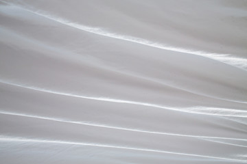 Obraz premium White bedsheet drying in the sun, Wrinkled texture, Abstract background, Close up shot, Selective focus, Housework, Laundry concept