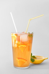 Glass of tasty cold ice tea on grey background