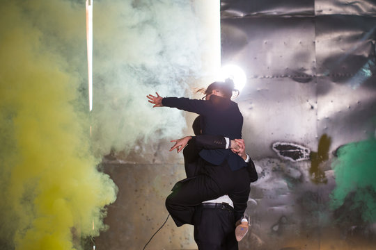 Pasadoble, latin solo dance and contemporary dance - Handsome man and woman dancing into smoke cloud.