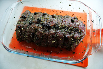 Beef and beef meat in a glass plate. Raw roast beef in spices. Cooking meat marinating in spices and herbs