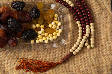 food Ramadan Sweets mixed of dried fruits and nuts Glass Tea with  rosary and the Quran on the table,