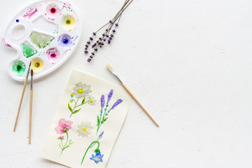 Drawing flowers with watercolor paintis on white background top-down copy space