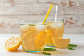 Glasses of tasty cold ice tea on white wooden background