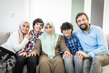 Happy Muslim family portrait on sofa