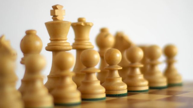 White chess figures on a light background with focus shift