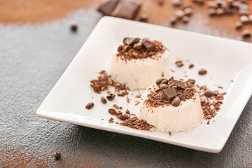 Plate with tasty panna cotta on dark background