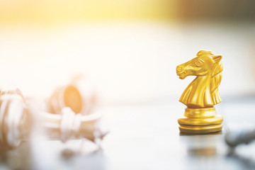 golden chess horse moving on a chessboard game fallen silver color tone victory success. strategy ideas Planning and Decision concept business leader. 