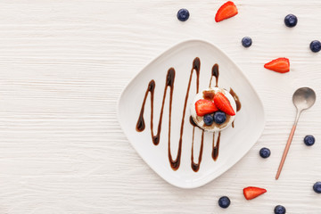 Plate with tasty panna cotta on table