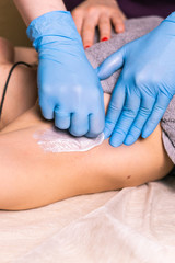 Waxing woman armpit. Salon wax beautician epilation procedure. Waxing female body for hair removal by therapist close up. Smooth underarm concept.
