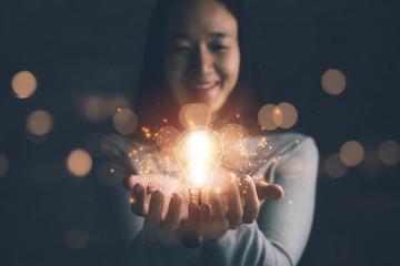 concept of creativity with bulbs that shine glitter.Hand of businesswoman holding illuminated light...