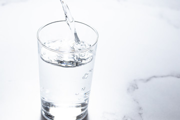 水をグラスに注ぐ。水分補給。健康・スポーツやトレーニング。